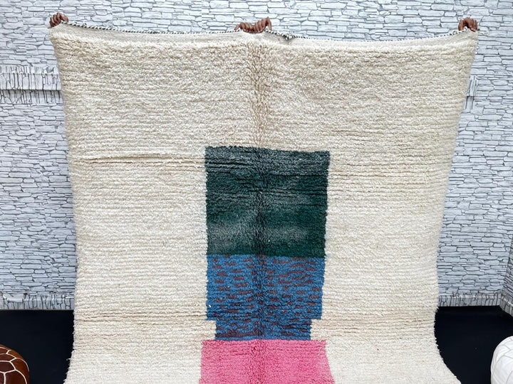 Modern Moroccan wool rug with ivory background and color blocks in green, blue, pink, mustard, and red