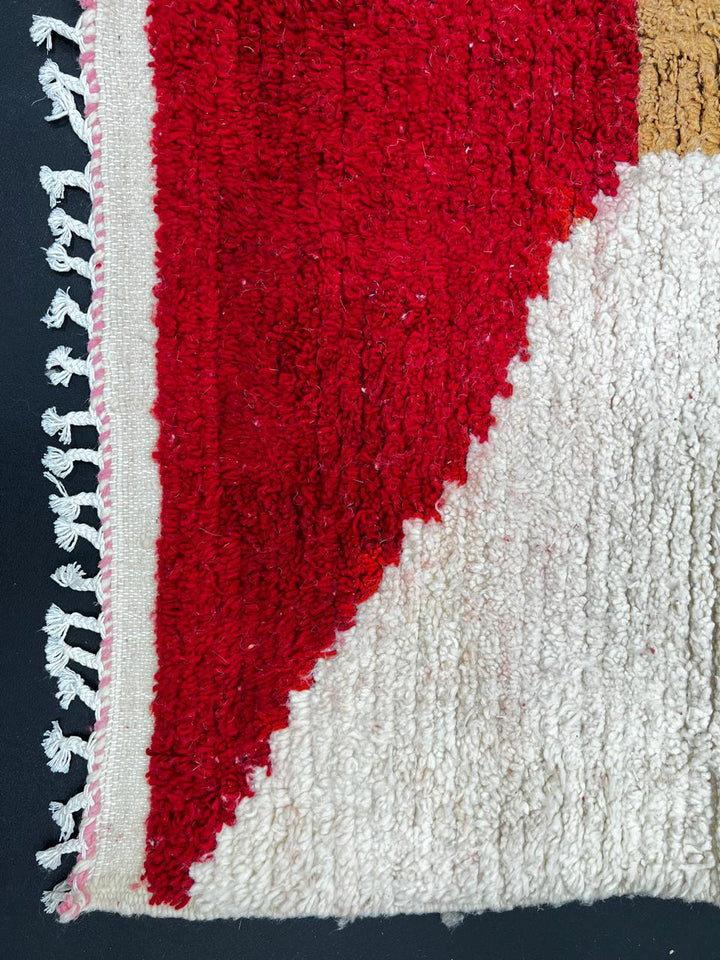 Modern Moroccan wool rug with ivory background and color blocks in green, blue, pink, mustard, and red