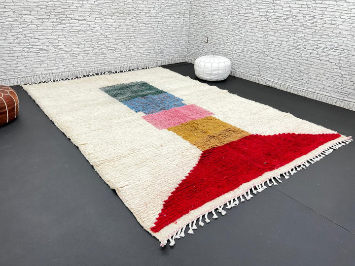 Modern Moroccan wool rug with ivory background and color blocks in green, blue, pink, mustard, and red