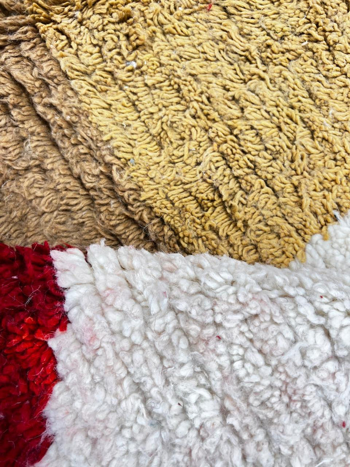 Modern Moroccan wool rug with ivory background and color blocks in green, blue, pink, mustard, and red