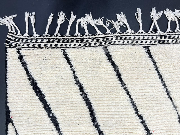 Handwoven Moroccan wool rug with black geometric diamond line pattern