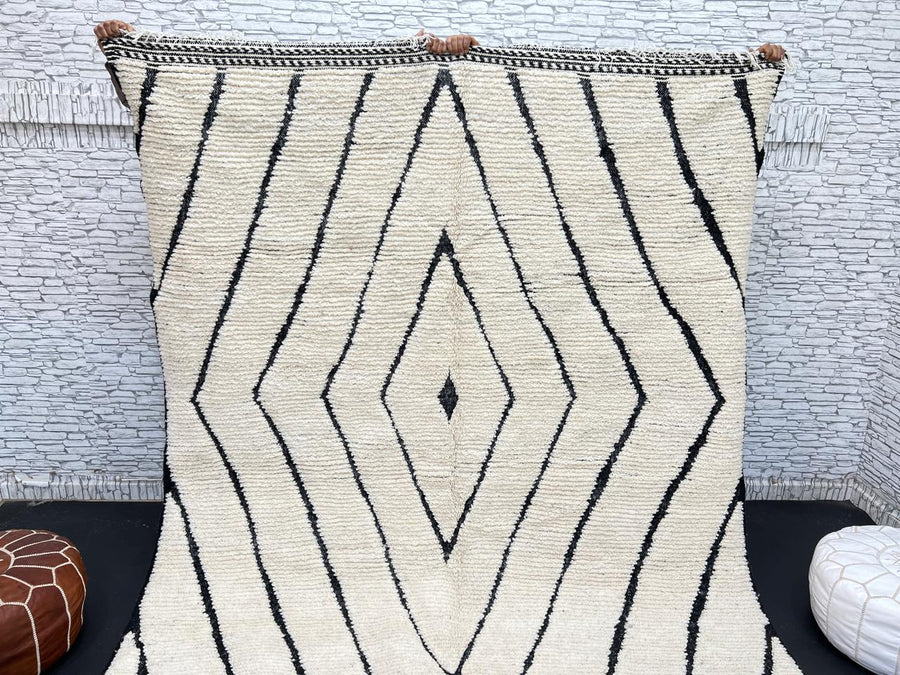 Handwoven Moroccan wool rug with black geometric diamond line pattern