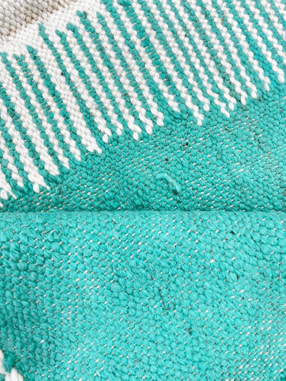 Modern abstract flat-weave round Moroccan wool rug in mint green, ivory, and blush tones