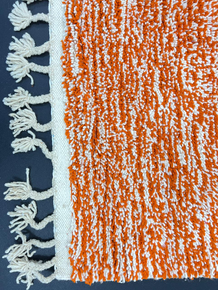 Handmade Moroccan wool rug with geometric color block design in orange, black, teal, and pink tones