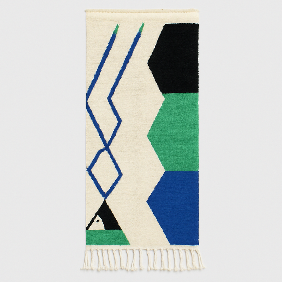 Handmade Moroccan runner rug with geometric blue, green, and black shapes on a white wool background.