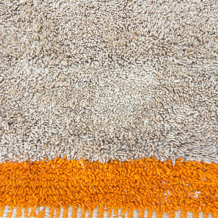 Handmade Moroccan wool rug with minimalist earth-tone design. Soft plush texture, modern style, and ethically crafted in Morocco.