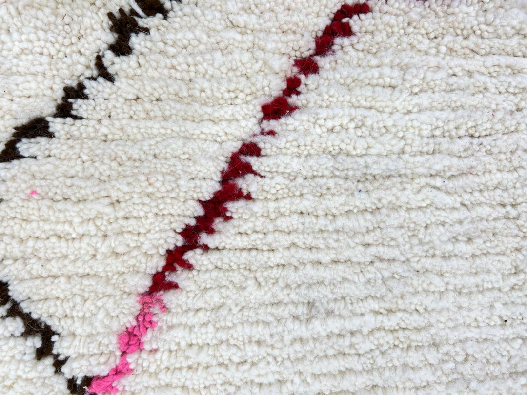 Modern Moroccan Berber wool rug with colorful geometric patterns on a cream background