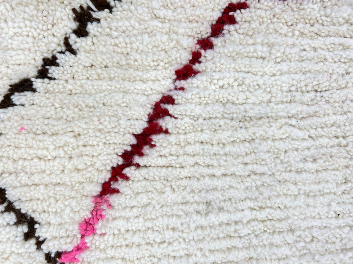 Modern Moroccan Berber wool rug with colorful geometric patterns on a cream background