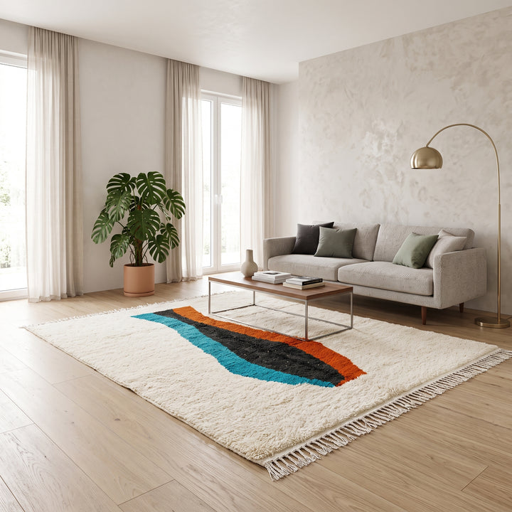 Beige Moroccan wool rug with central abstract design in blue, black, and orange, handmade by Berber artisans