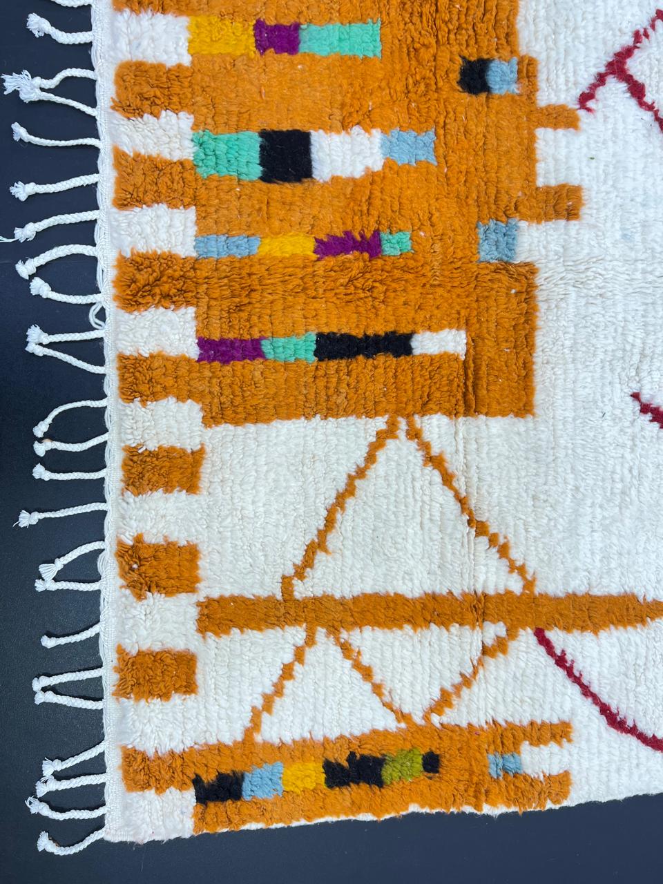 Modern Moroccan wool rug with abstract burgundy lines and golden geometric pattern on a white background