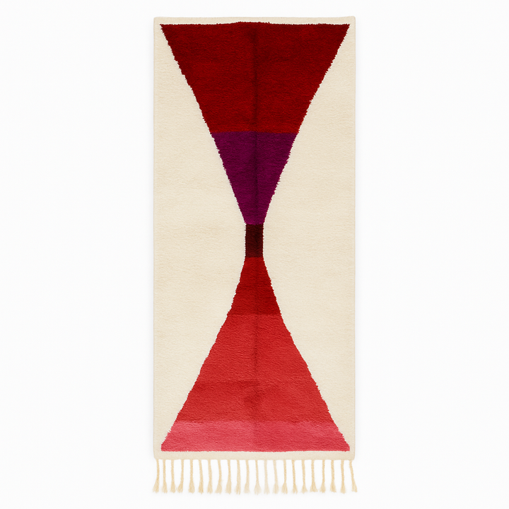 Handmade modern Moroccan wool runner rug with red, burgundy, and pink geometric hourglass design on white background