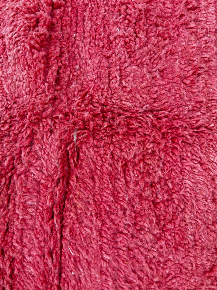 Handmade modern Moroccan wool runner rug with red, burgundy, and pink geometric hourglass design on white background