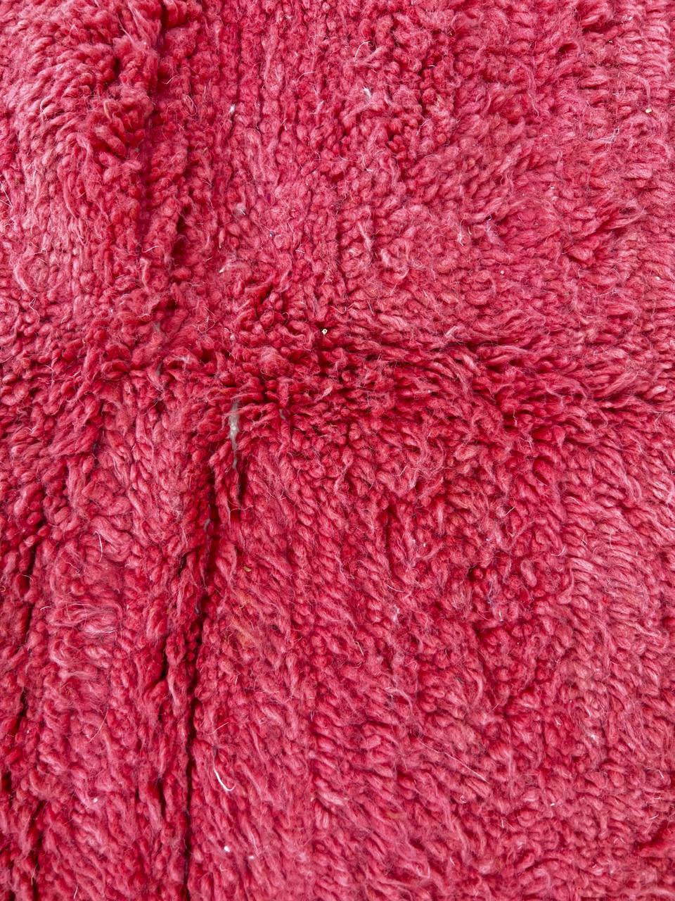 Handmade modern Moroccan wool runner rug with red, burgundy, and pink geometric hourglass design on white background