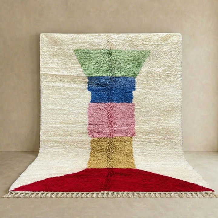 Handwoven Moroccan wool rug with ivory background and colorful geometric blocks in green, blue, pink, mustard, and red 
