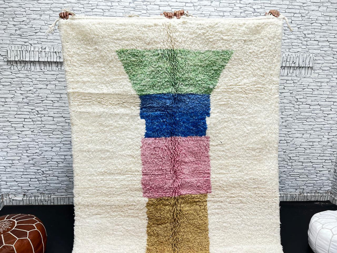 Handwoven Moroccan wool rug with ivory background and colorful geometric blocks in green, blue, pink, mustard, and red