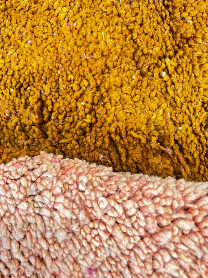 Modern round Moroccan wool rug with pink, orange, terracotta, and blue abstract color-block design