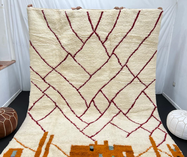 Modern Moroccan wool rug with abstract burgundy lines and golden geometric pattern on a white background