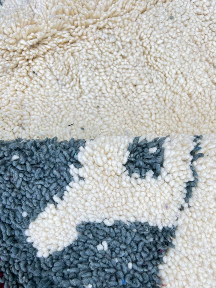 Handmade modern Moroccan wool runner rug with black, green, mint, grey, and magenta geometric abstract patterns on a white background