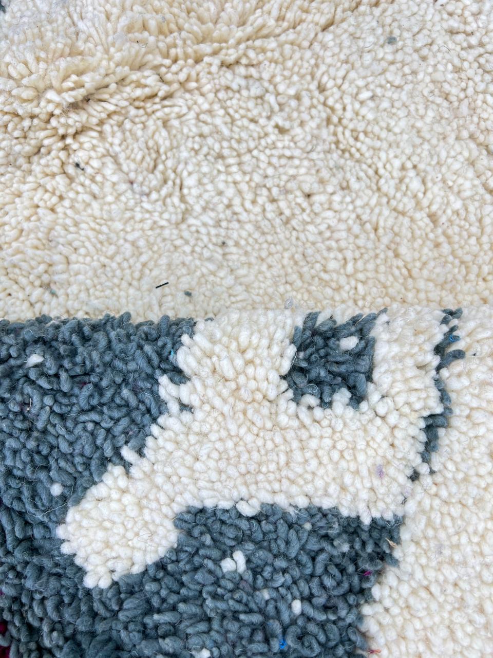 Handmade modern Moroccan wool runner rug with black, green, mint, grey, and magenta geometric abstract patterns on a white background