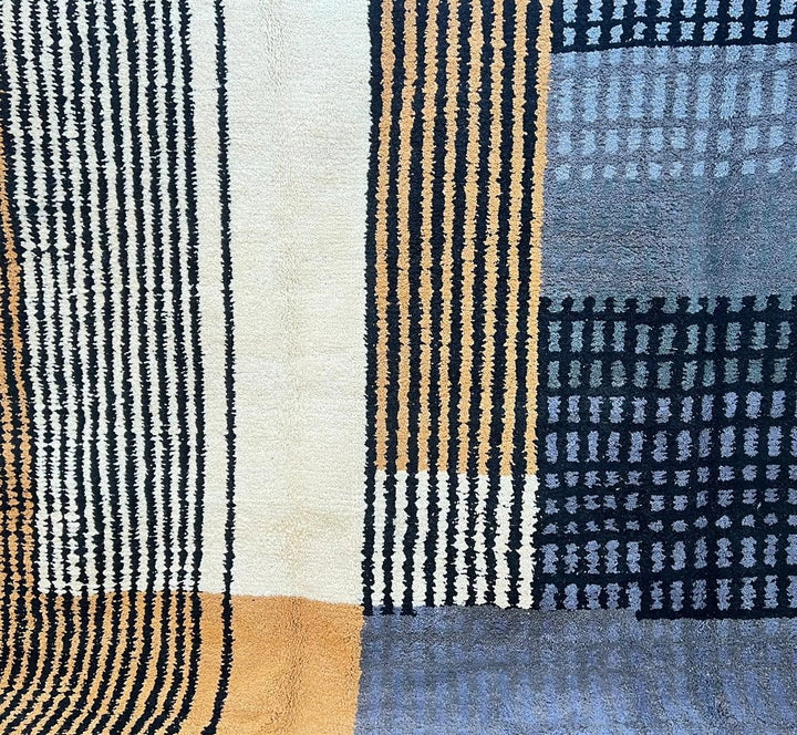 Round handmade Moroccan wool rug with modern geometric striped design in mustard, black, gray and ivory tones