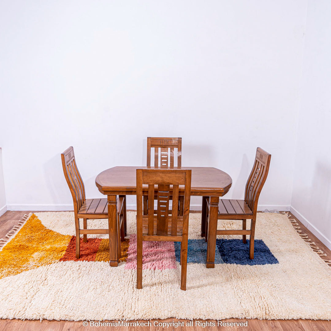Handmade Moroccan rug with colorful geometric design under wooden dining table