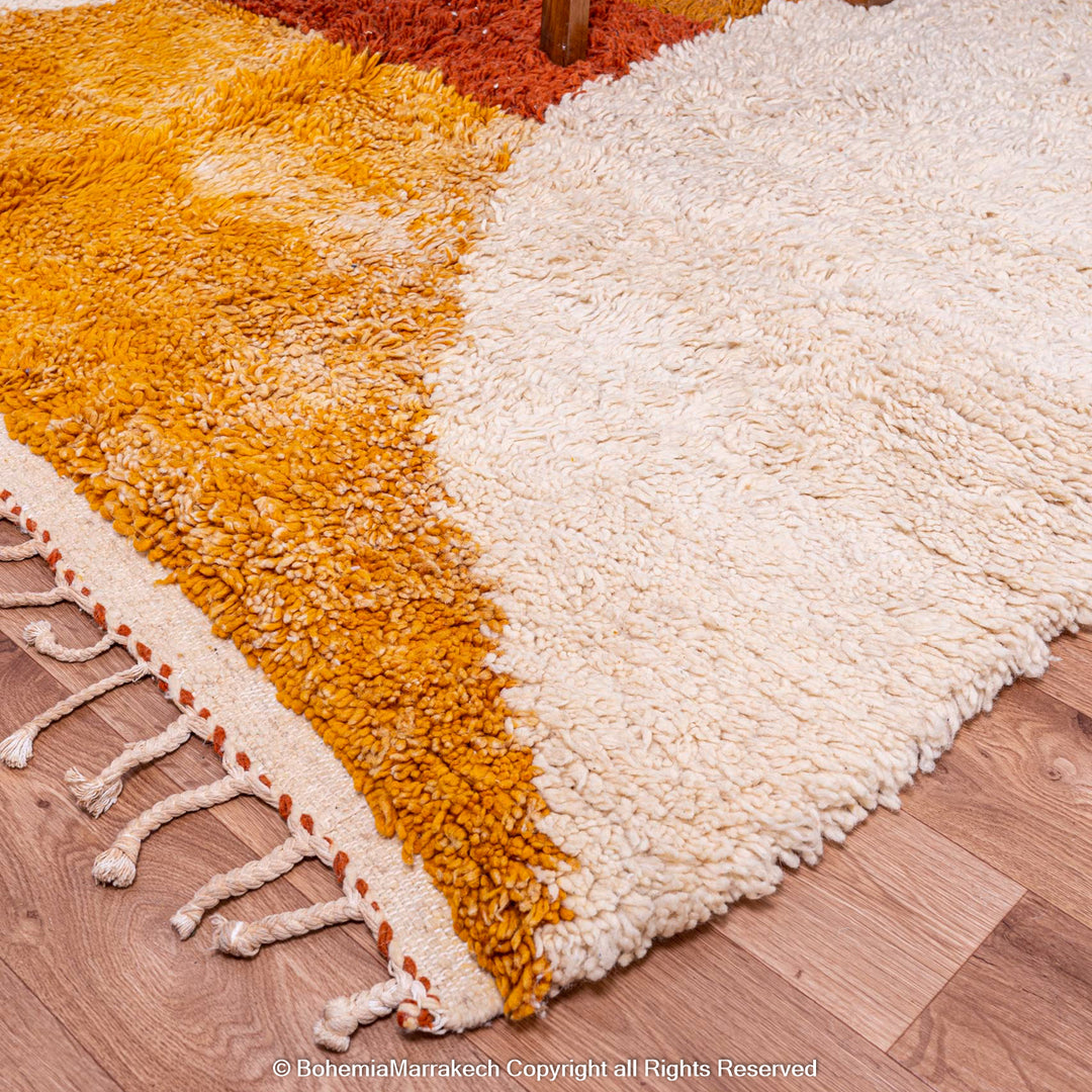 Colorful handmade Moroccan wool shag rug with geometric design, featuring orange and cream blocks, ideal for modern home decor.