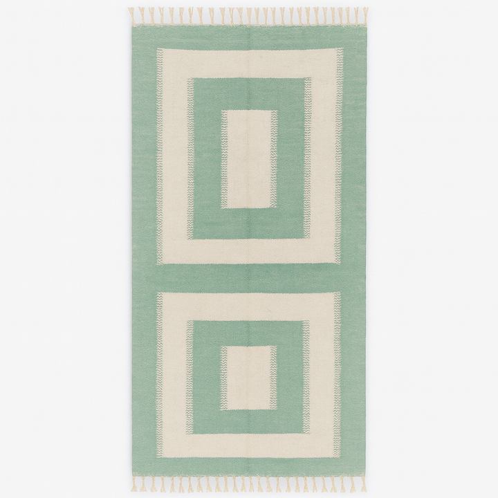 Handmade Moroccan kilim runner rug with green and white geometric block design, minimalist flatwoven hallway rug displayed with Moroccan poufs