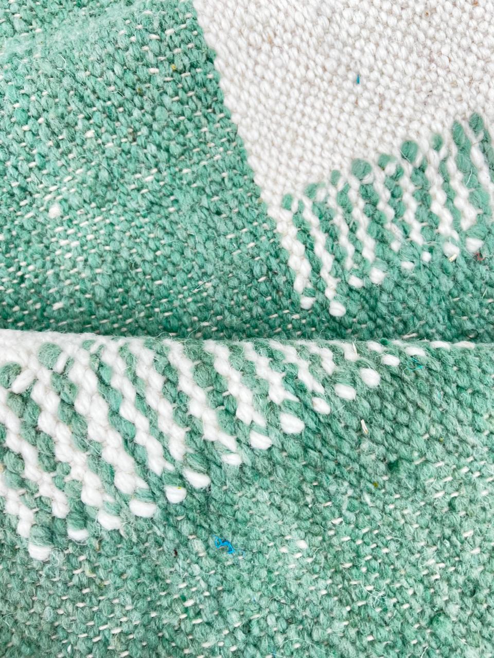 Handmade Moroccan kilim runner rug with green and white geometric block design, minimalist flatwoven hallway rug displayed with Moroccan poufs