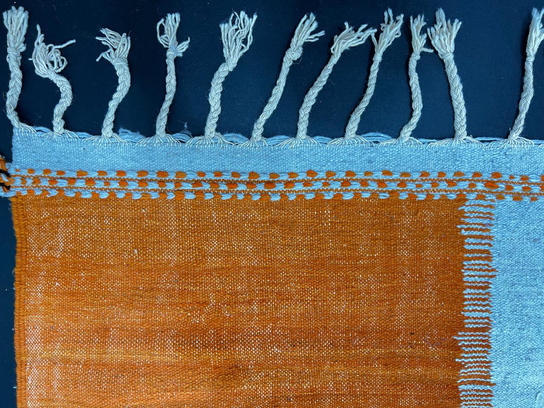 Handwoven Moroccan kilim runner rug with modern orange, purple, and cream abstract geometric pattern in flatweave wool.