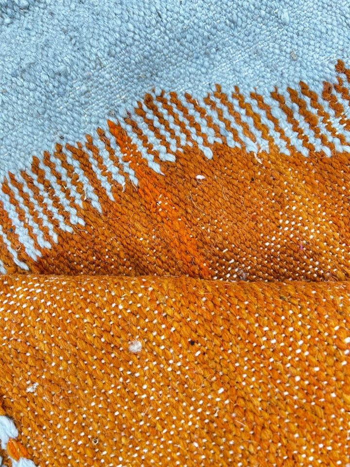 Handwoven Moroccan kilim runner rug with modern orange, purple, and cream abstract geometric pattern in flatweave wool.