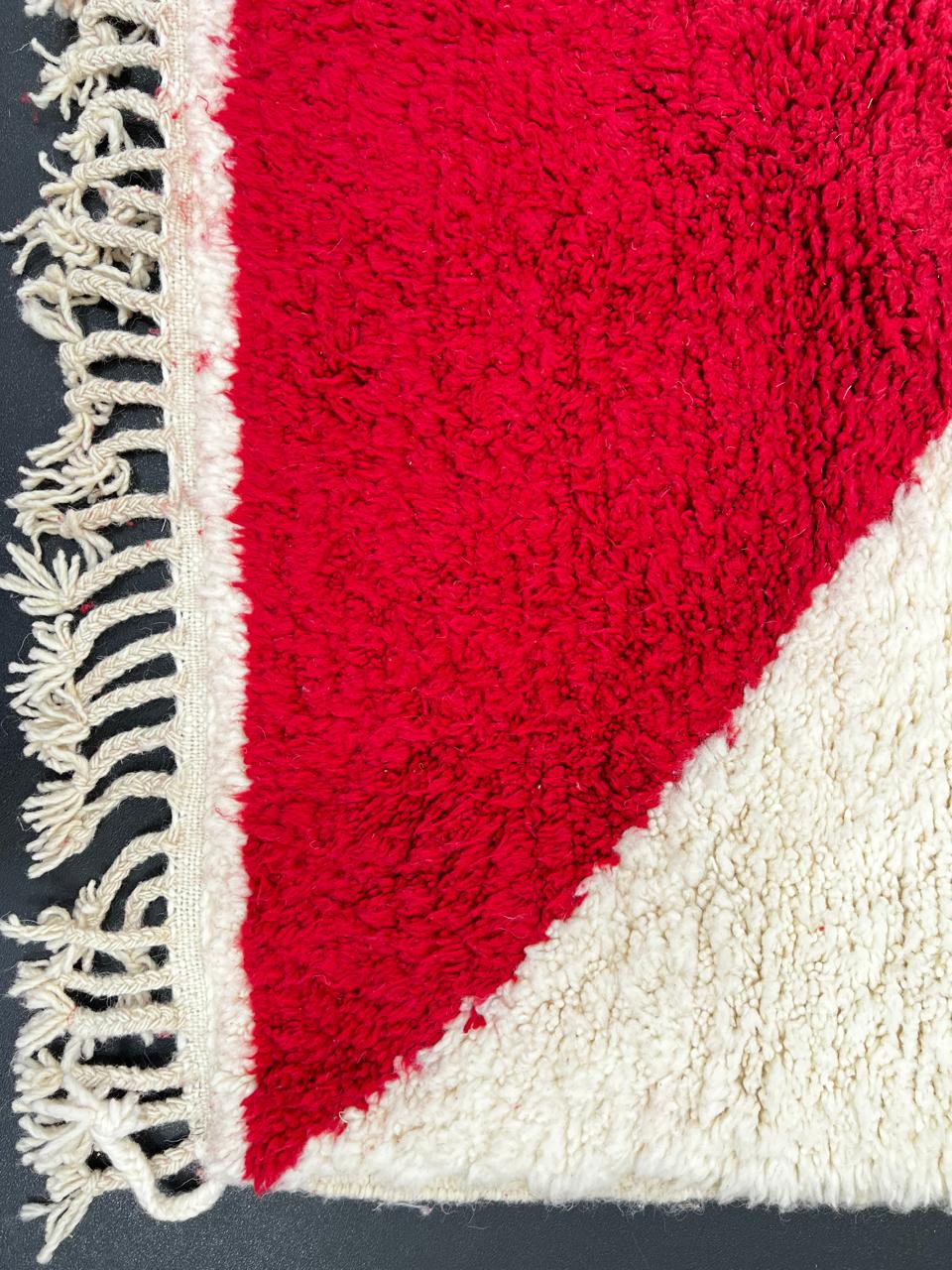 Handmade Moroccan runner rug with colorful geometric design in red, blue, pink, green and mustard on white  wool background