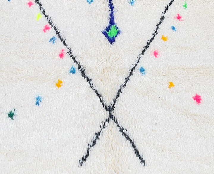 White round Moroccan wool rug with colorful tribal and geometric motifs.