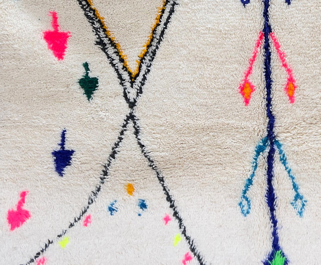 White round Moroccan wool rug with colorful tribal and geometric motifs.