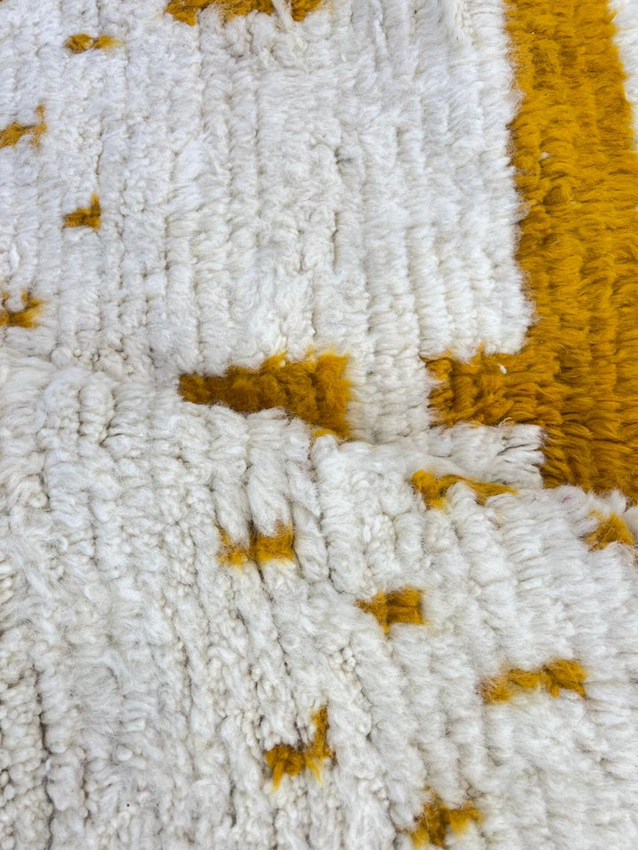 Golden symbolic Moroccan runner rug handwoven in white and mustard wool with raised tribal pattern