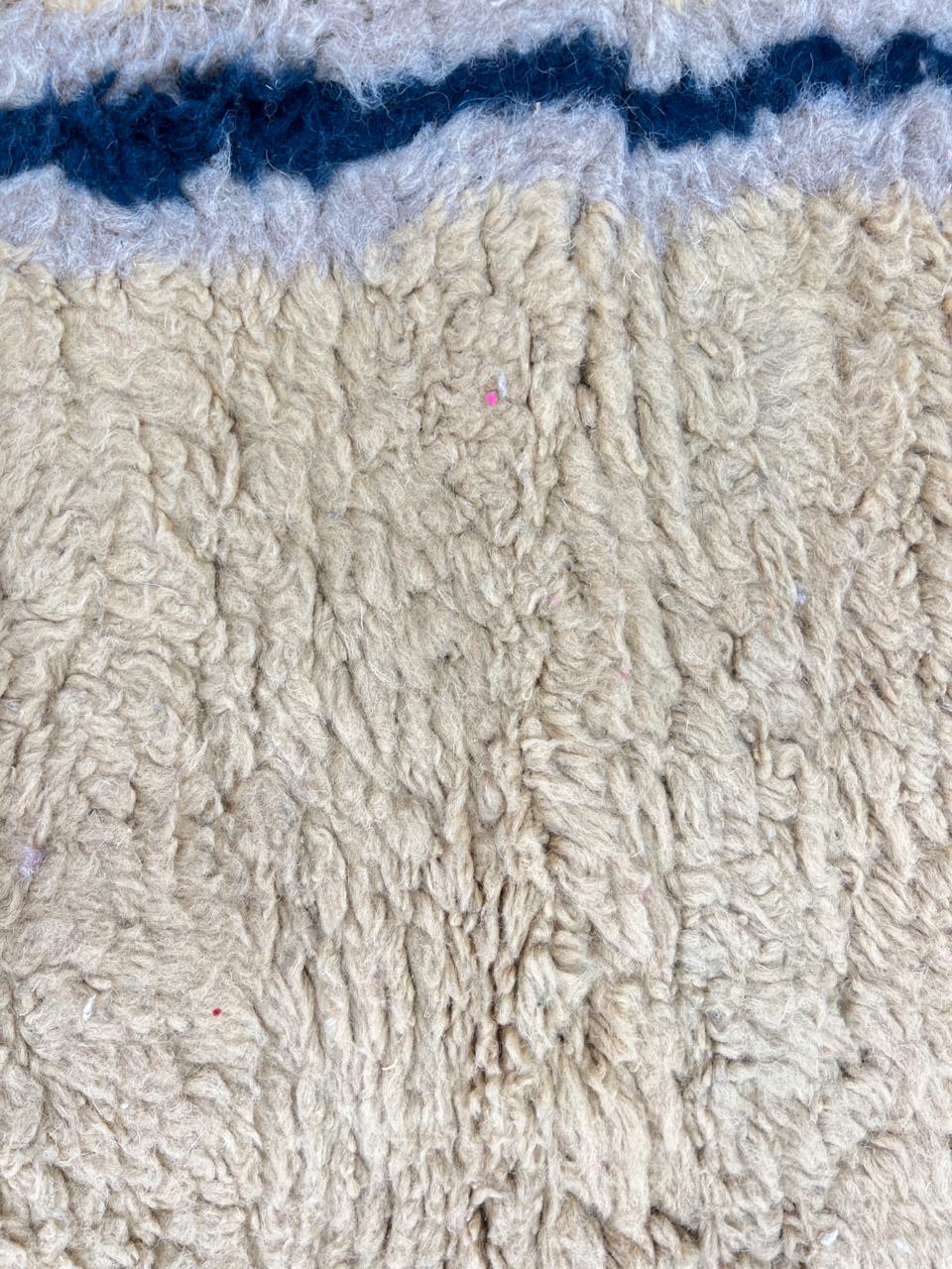 Moroccan wool runner rug with deep blue border design, handmade Beni Ourain Berber carpet, soft shag texture and traditional geometric pattern
