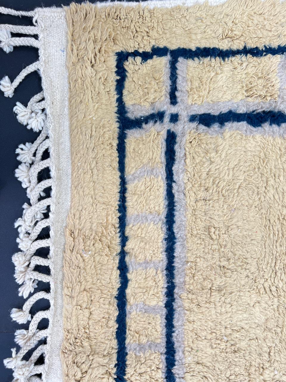 Moroccan wool runner rug with deep blue border design, handmade Beni Ourain Berber carpet, soft shag texture and traditional geometric pattern