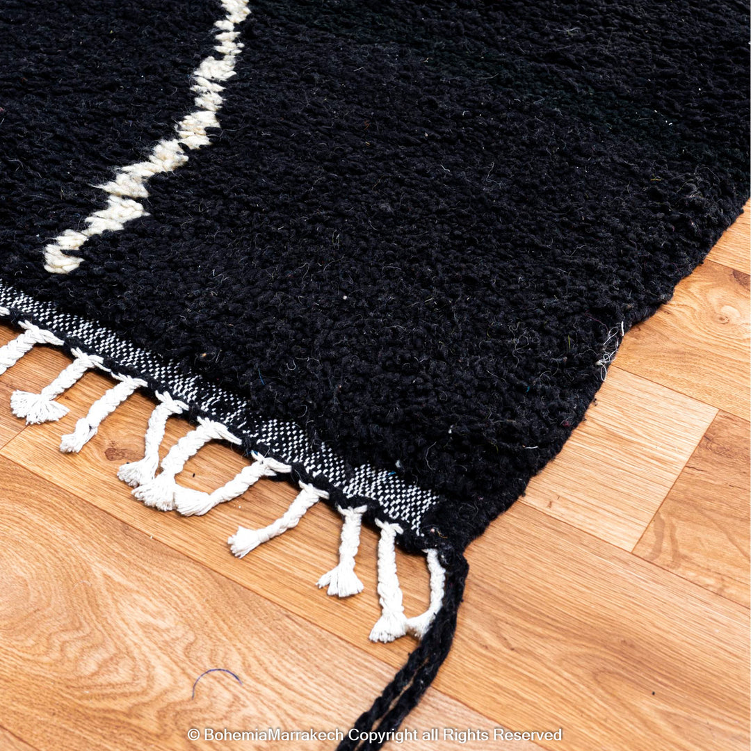 Solid black Moroccan rug with hand-knotted white tribal lines