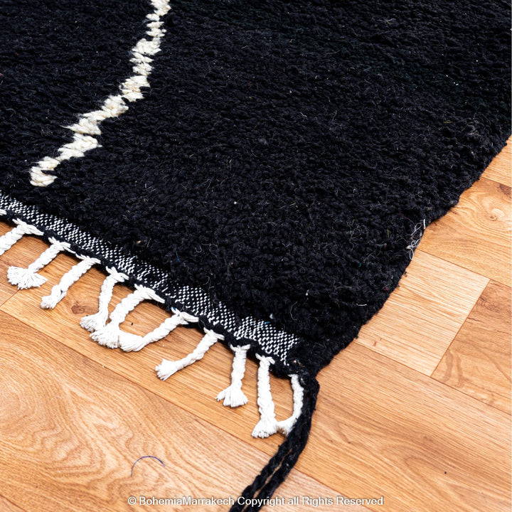 Solid black Moroccan rug with hand-knotted white tribal lines