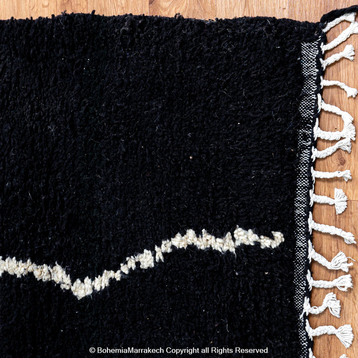 Solid black Moroccan rug with hand-knotted white tribal lines