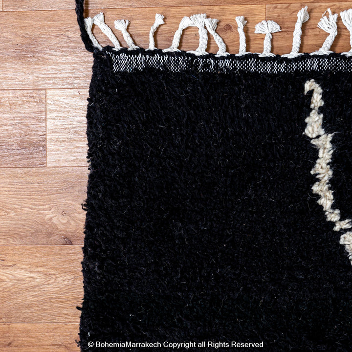 Solid black Moroccan rug with hand-knotted white tribal lines