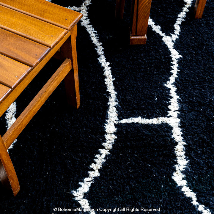 Solid black Moroccan rug with hand-knotted white tribal lines