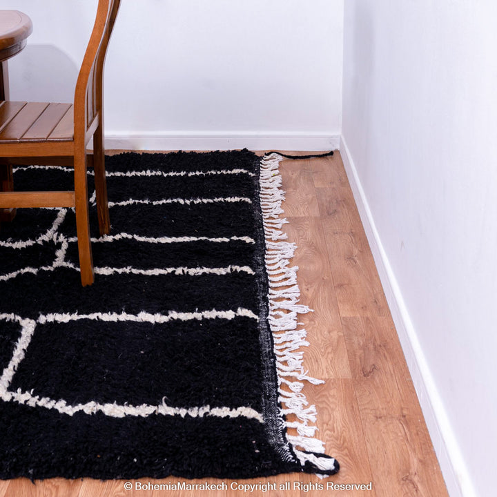 Solid black Moroccan rug with hand-knotted white tribal lines