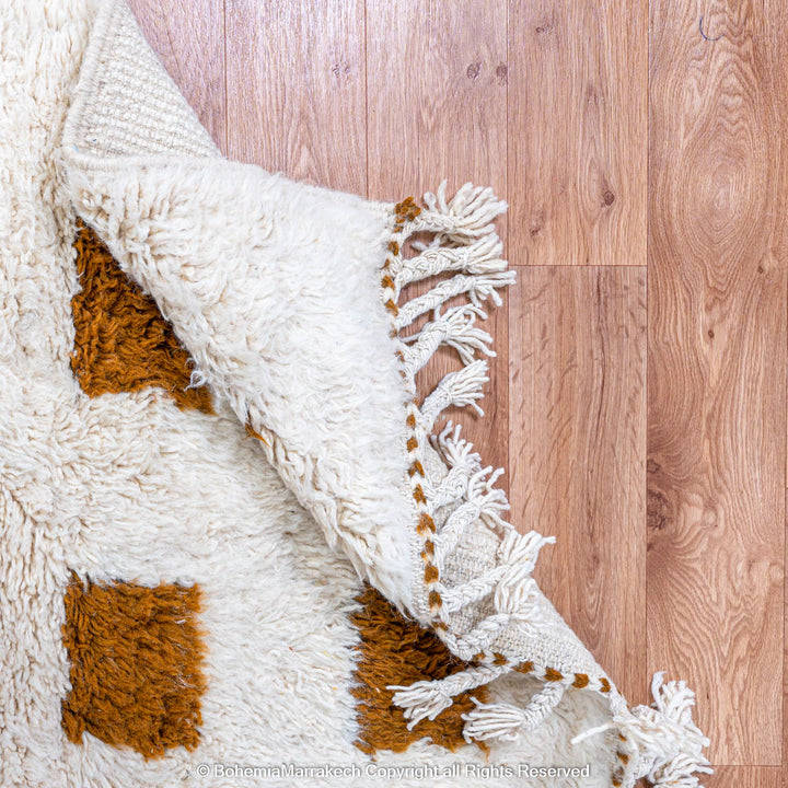 Handmade Moroccan rug with brown checkered pattern on white wool background