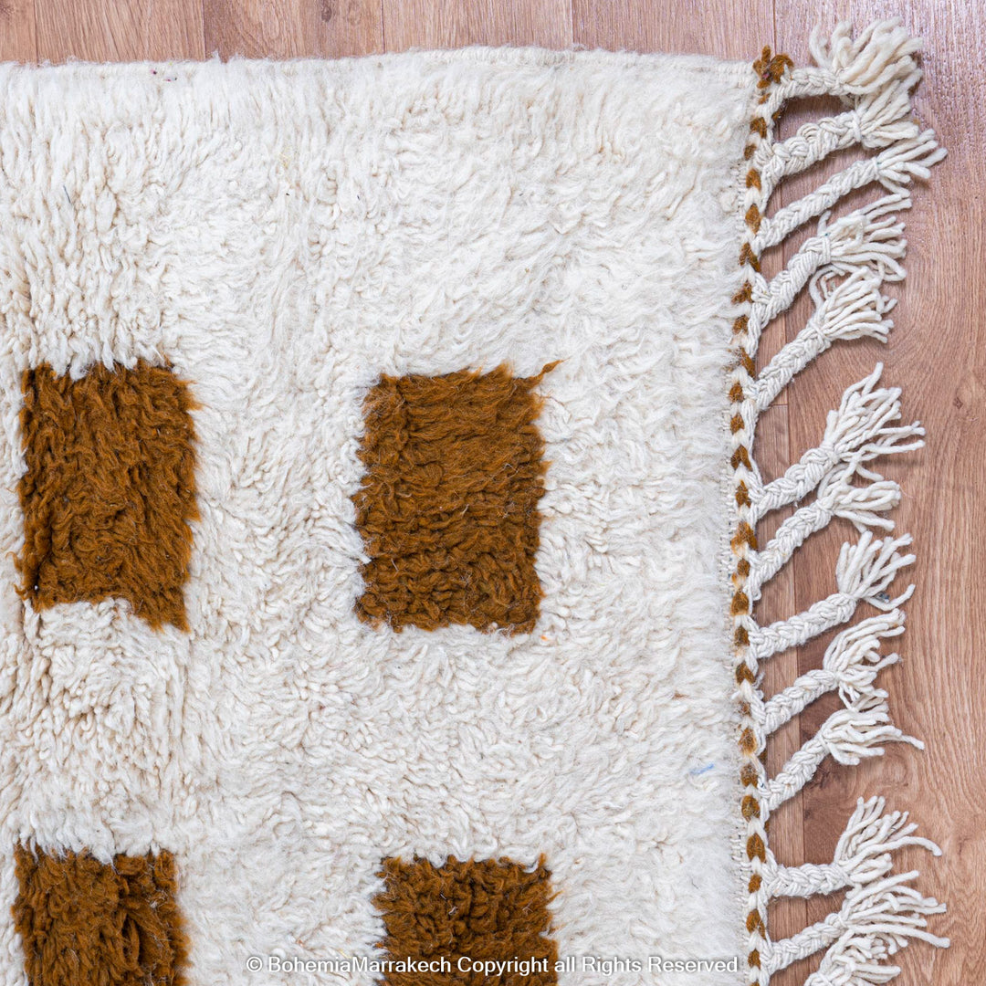 Handmade Moroccan rug with brown checkered pattern on white wool background