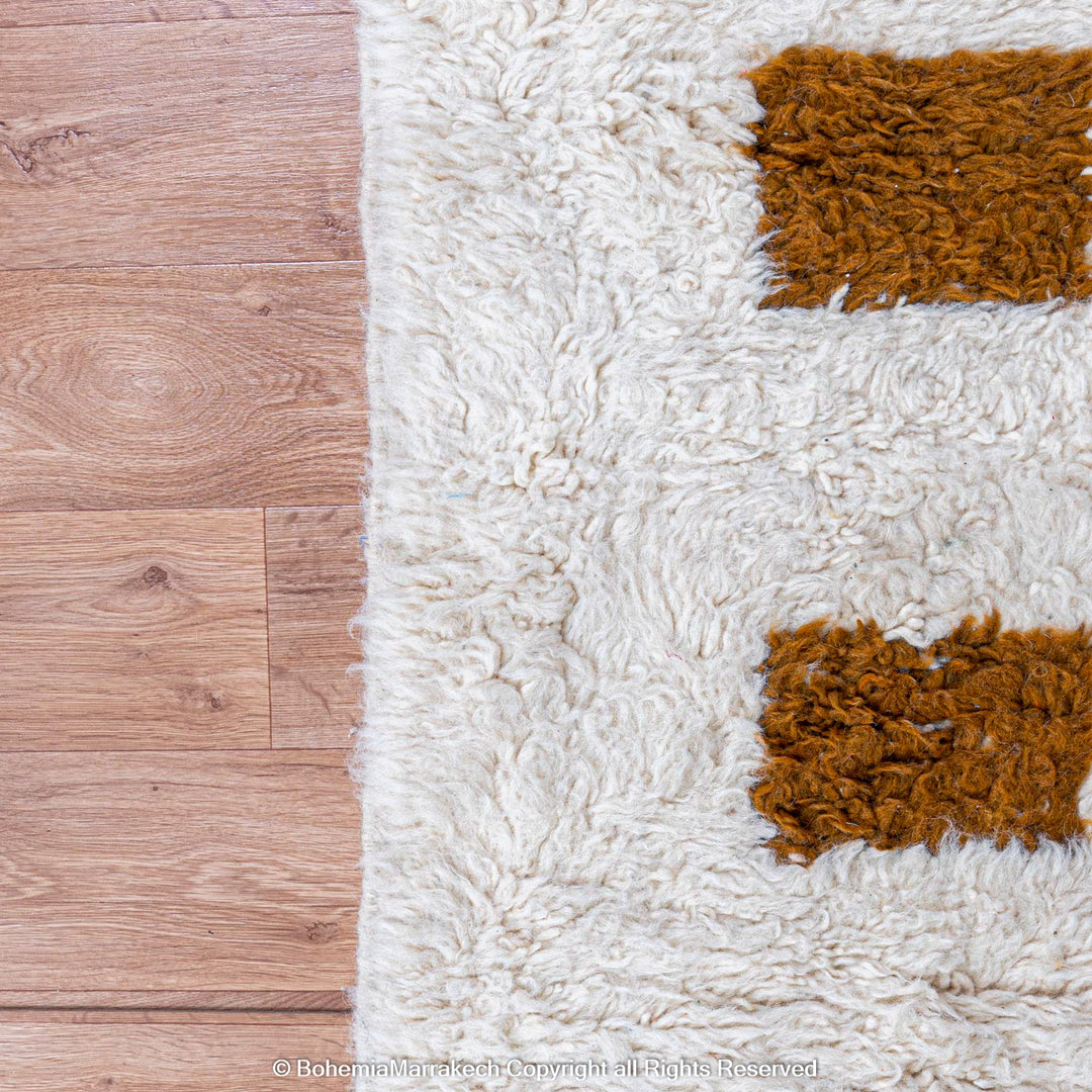 Handmade Moroccan rug with brown checkered pattern on white wool background