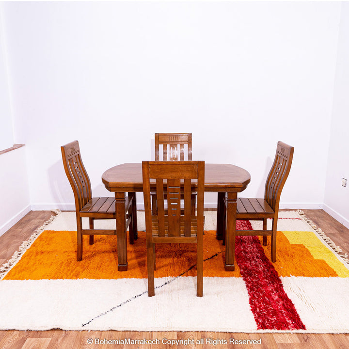 Handwoven Moroccan rug in orange, red, and white color blocks with symbolic Berber motif and soft wool texture