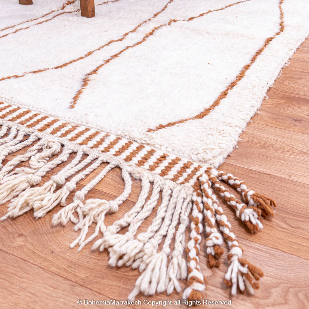 Hand-knotted Moroccan Beni Ourain wool rug with abstract brown Berber motifs on a white background