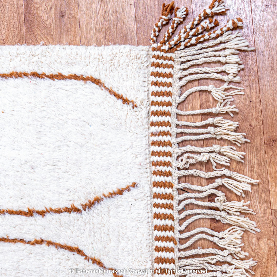 Hand-knotted Moroccan Beni Ourain wool rug with abstract brown Berber motifs on a white background