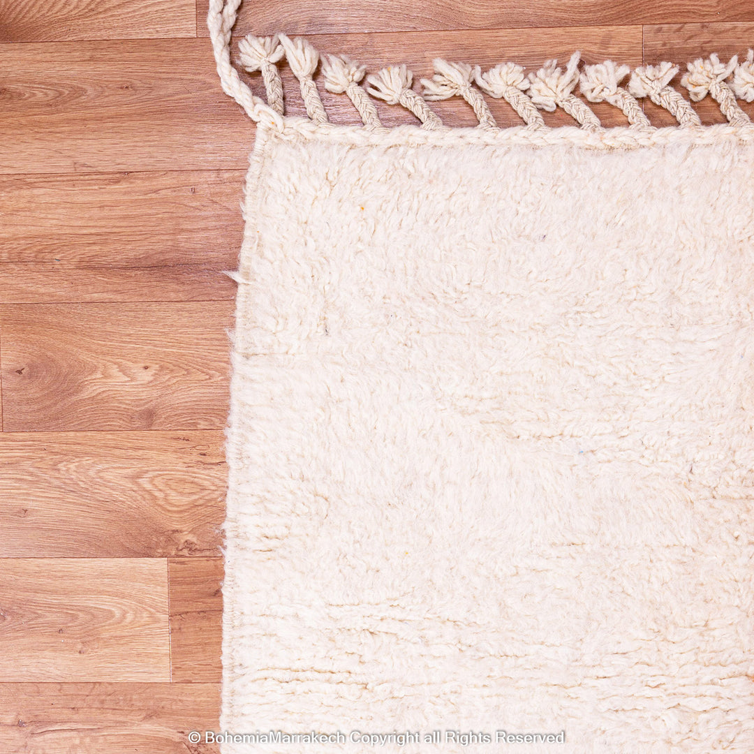 Handwoven Moroccan rug in orange, red, and white color blocks with symbolic Berber motif and soft wool texture