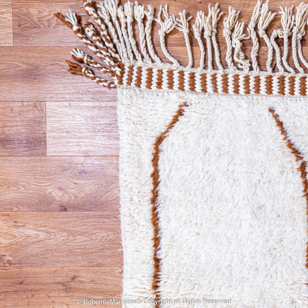 Hand-knotted Moroccan Beni Ourain wool rug with abstract brown Berber motifs on a white background